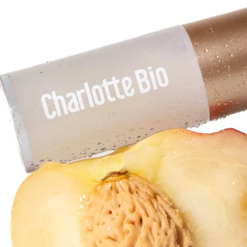 Charlotte Bio Økologisk Læbeolie Naturlig Glød – tube nærbillede med abrikoskerne