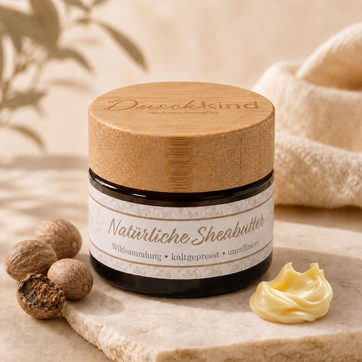 Duschkind Naturlig Sheabutter i glas med sheanødder og smørklat på stenplade