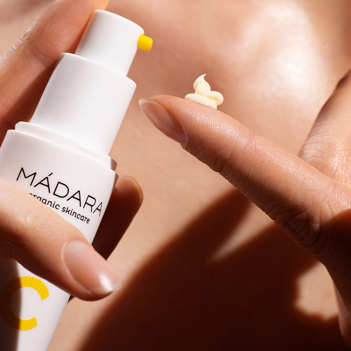 Mádara C-vitamin Lysnende Genoprettelsescreme tekstur på finger – let og fugtig formel 